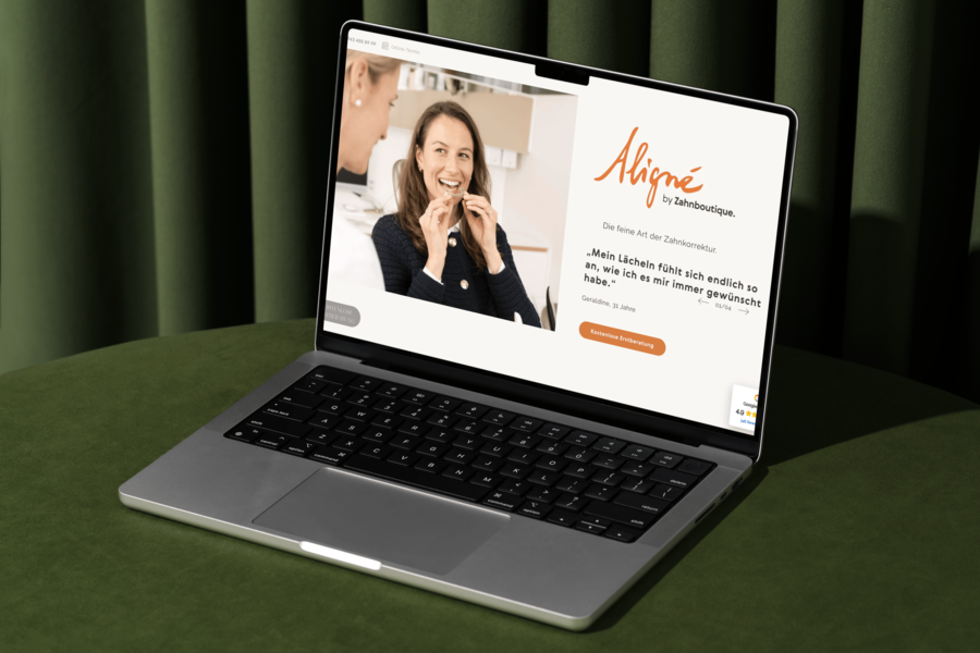 Ein 13" MacBook steht auf einem gr&uuml;nen Samthocker und zeigt die Website von Align&eacute; der Zahnboutique am Kreuzplatz in Z&uuml;rich